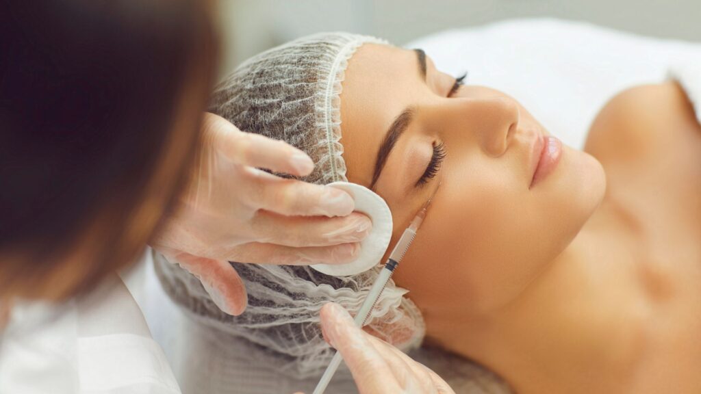 Female Beautician Makes Injections to a Girl's Cheekbone to Smooth Facial Wrinkles