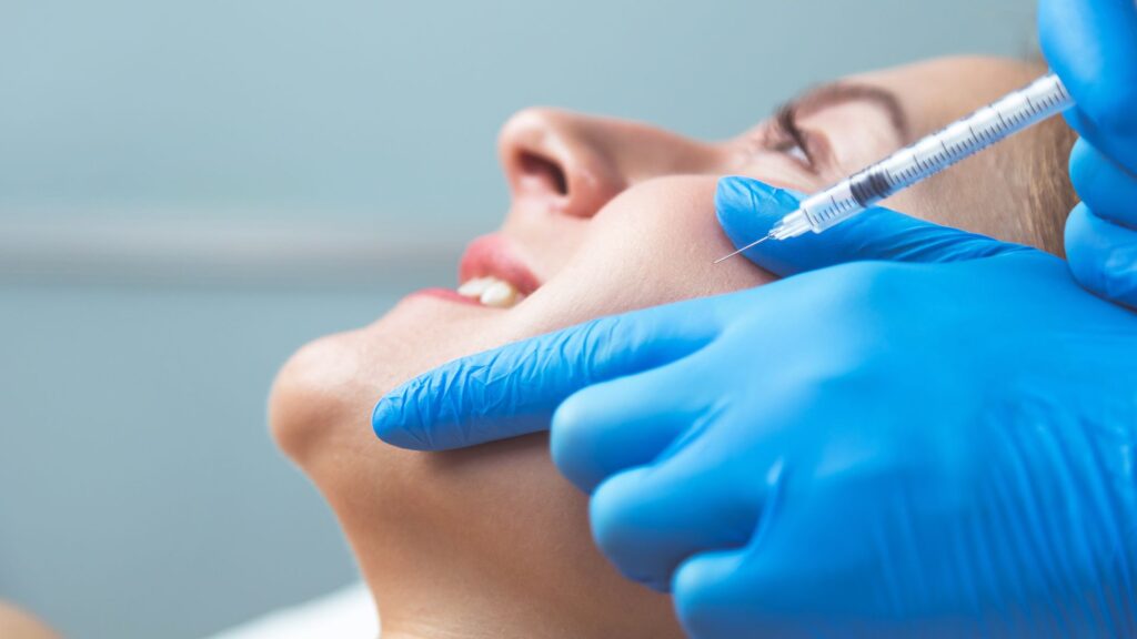 Close-up of a patient receiving a dental botox injection in the masseter area for facial rejuvenation and TMJ pain relief.