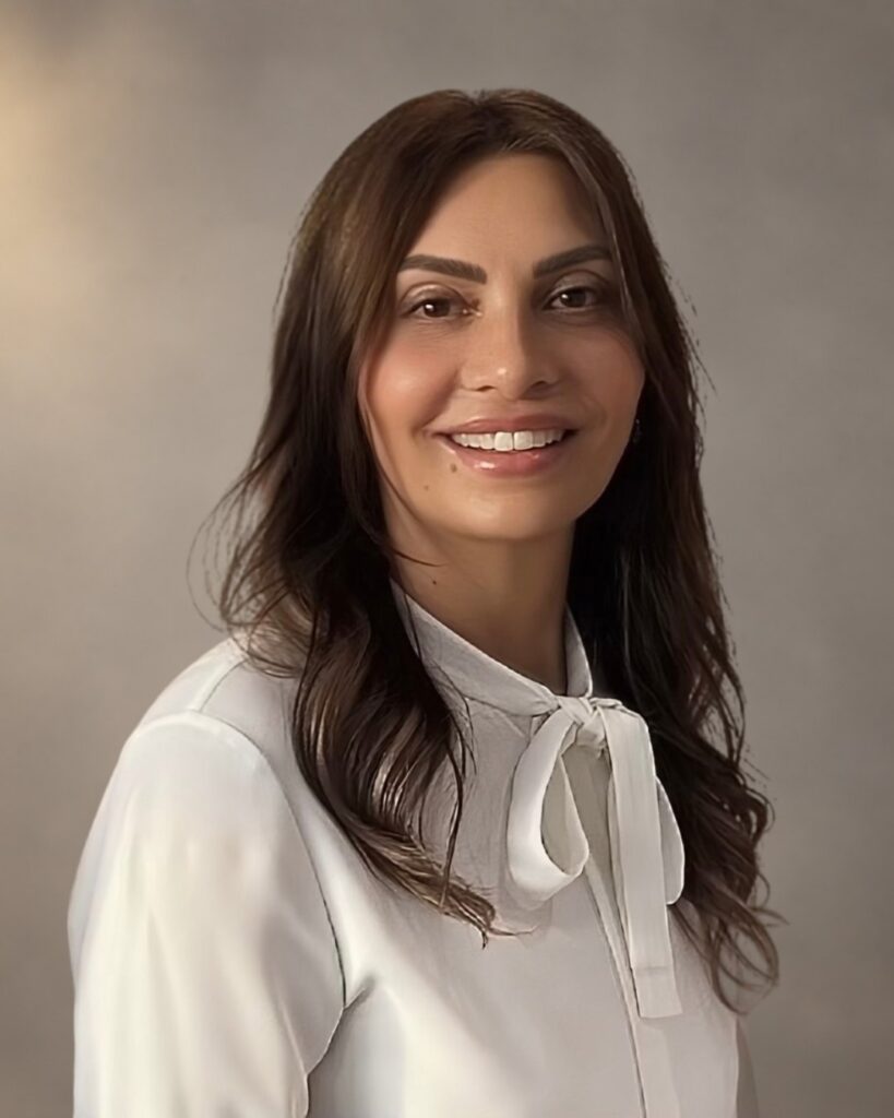 Professional headshot of Jasbinder Wells smiling and wearing a white blouse.